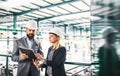 A portrait of an industrial man and woman engineer with clipboard in a factory. Royalty Free Stock Photo