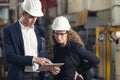 A portrait of an industrial man and woman engineer with tablet in a factory, working