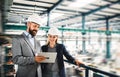 A portrait of an industrial man and woman engineer with tablet in a factory, working. Royalty Free Stock Photo