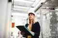 A portrait of an industrial woman engineer in a factory checking something. Royalty Free Stock Photo