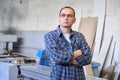 Portrait of industrial worker, man with arms crossed in carpentry workshop