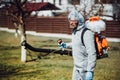 Industrial worker wearing protective clothing and spraying pesticides, insecticides and other organic chemicals