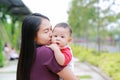 Portrait of Infant baby boy is sucking finger with Asian mother carrying Royalty Free Stock Photo