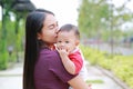 Portrait of Infant baby boy is sucking finger with Asian mother carrying Royalty Free Stock Photo