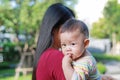 Portrait of Infant baby boy is sucking finger with Asian mother carrying Royalty Free Stock Photo