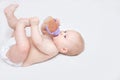 Infant is drinking from a bottle and lying