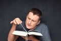 Portrait of inquisitive man reading big book and flipping page Royalty Free Stock Photo