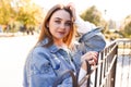 Portrait of inspired caucasian girl with trendy make-up in the street. Outdoor photo of smiling shy woman with light-brown hair