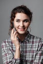 Portrait of an intelligent student with curly hair and with a phone in her hand. Checkered shirt