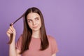 Portrait of interested girl touch fingers chin hair look copyspace think on violet background