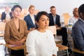 Hispanic female entrepreneur sitting in conference hall at business event