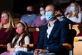 Man in protective mask watching theatrical performance