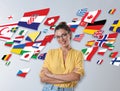 Portrait of interpreter in eyeglasses and flags of different countries on light background