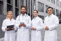 Portrait of an interracial young group of people, male and female doctors and scientists, standing outside a building in Royalty Free Stock Photo