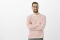 Portrait of intrigued pleasant handsome male in black glasses, smiling broadly, holding hands crossed on chest, smiling Royalty Free Stock Photo