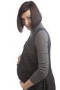 Portrait of Intriguing Smiling Cute Positive Caucasian Brunette Pregnant Woman in Grey Dress Posing Over Pure White Background