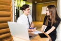 Portrait of investment advisor businessman sitting at office in front of computer and consulting with executive professional woman