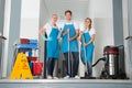 Portrait Of Janitors Holding Cleaning Equipments Royalty Free Stock Photo