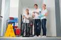 Portrait Of Janitors Holding Cleaning Equipments Royalty Free Stock Photo