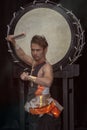 Portrait of a Japanese drummer Taiko with drumsticks and big drum