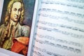 A portrait of Johann Sebastian Bach on the opened sheet music. Interior of musical room. Famous people and their works.