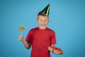 Joyful Birthday Boy Wearing Party Hat Holding Present And Hard Candy Royalty Free Stock Photo