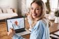 Portrait of joyful blond woman 20s using laptop and credit card for online shopping indoor