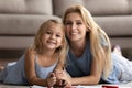 Portrait of blonde two female generations family lying on carpet. Royalty Free Stock Photo