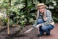 Portrait of joyful Caucasian gray haired senior lady in garden working with shovel and rake, smiling to camera. Happy Royalty Free Stock Photo