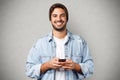 Portrait of joyful caucasian guy smiling holding smartphone