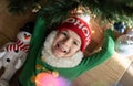 portrait of a joyful child, 7 year old boy lies under the Christmas tree Royalty Free Stock Photo