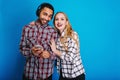 Portrait joyful couple of attarctive young woman with long blonde hair having fun together with handsome guy listening Royalty Free Stock Photo