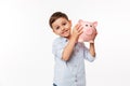 Portrait of a joyful cute little kid holding piggy bank