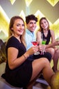 Portrait of joyful friends sitting in nightclub