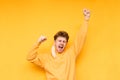 Portrait of a joyful guy with a removed medical mask on a yellow background, a man rejoices at the end of carotene. Happy young