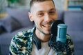 Portrait of joyful guy talking in microphone in recording studio smiling Royalty Free Stock Photo