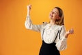 Portrait of a joyful happy teenage girl celebrating success on yellow background Royalty Free Stock Photo