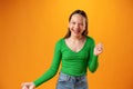 Portrait of a joyful happy teenage girl celebrating success on yellow background Royalty Free Stock Photo