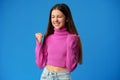 Portrait of a joyful happy teenage girl celebrating success on blue background Royalty Free Stock Photo