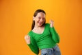 Portrait of a joyful happy teenage girl celebrating success on yellow background Royalty Free Stock Photo