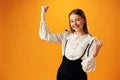 Portrait of a joyful happy teenage girl celebrating success on yellow background Royalty Free Stock Photo