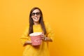 Portrait of joyful happy young girl in 3d imax glasses watching movie film and eating popcorn from bucket isolated on Royalty Free Stock Photo