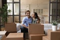 Portrait of joyful homeowners resting in renovated apartment.