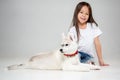 Portrait of a joyful little girl having fun with siberian husky puppy on the floor at studio Royalty Free Stock Photo