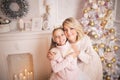 Portrait of a joyful mom and daughter against the background of the Christmas interior Royalty Free Stock Photo