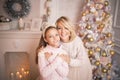 Portrait of a joyful mom and daughter against the background of the Christmas interior Royalty Free Stock Photo