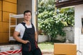 Portrait of a joyful mover working unloading boxes from a truck into a new home Royalty Free Stock Photo