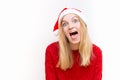 Portrait of joyful pretty woman, emotional girl in santa claus christmas hat showing tongue at the camera. Holiday