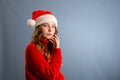 Portrait of joyful pretty woman in red santa claus hat laughing isolated on gray background. Beautiful girl looking happy and Royalty Free Stock Photo