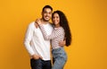 Portrait of joyful romantic middle-eastern couple embracing while posing over yellow background Royalty Free Stock Photo